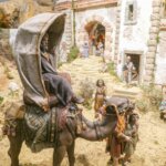 Representación de una escena de la natividad con figuras en un paisaje árido.