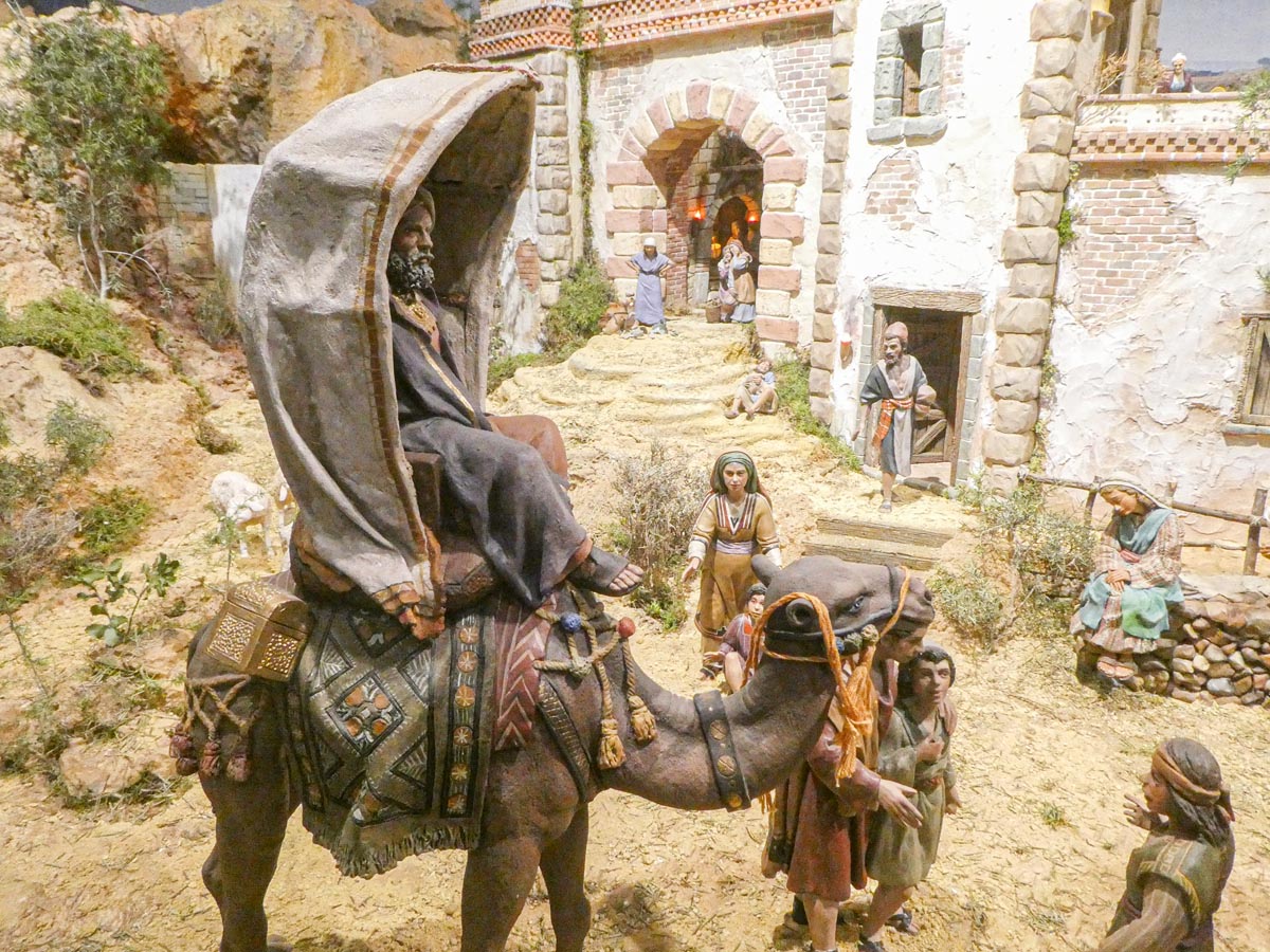 Representación de una escena de la natividad con figuras en un paisaje árido.