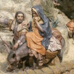 Figuras artesanales de la natividad con personajes en un burro.