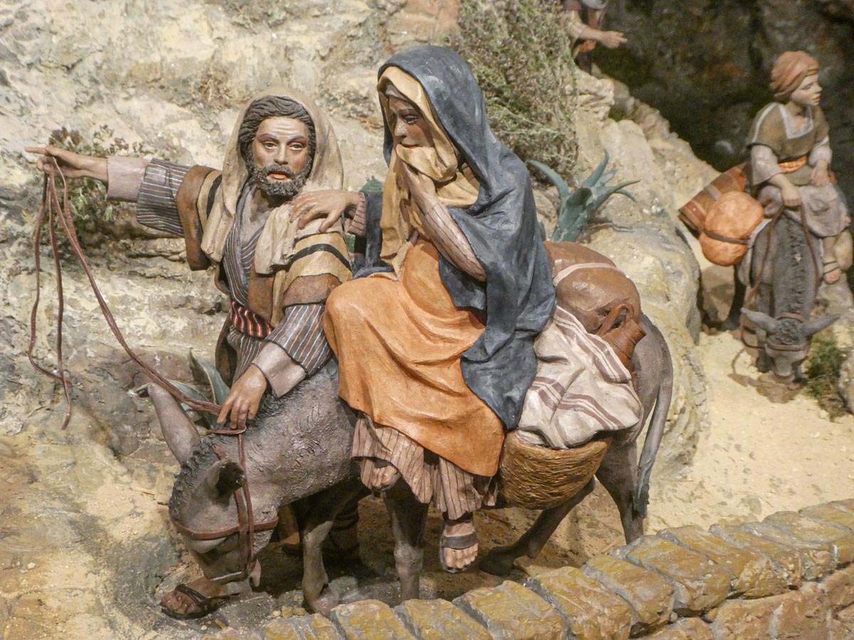 Figuras artesanales de la natividad con personajes en un burro.