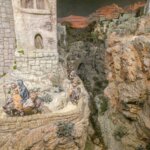 Representación de una escena histórica con figuras en un paisaje rocoso.