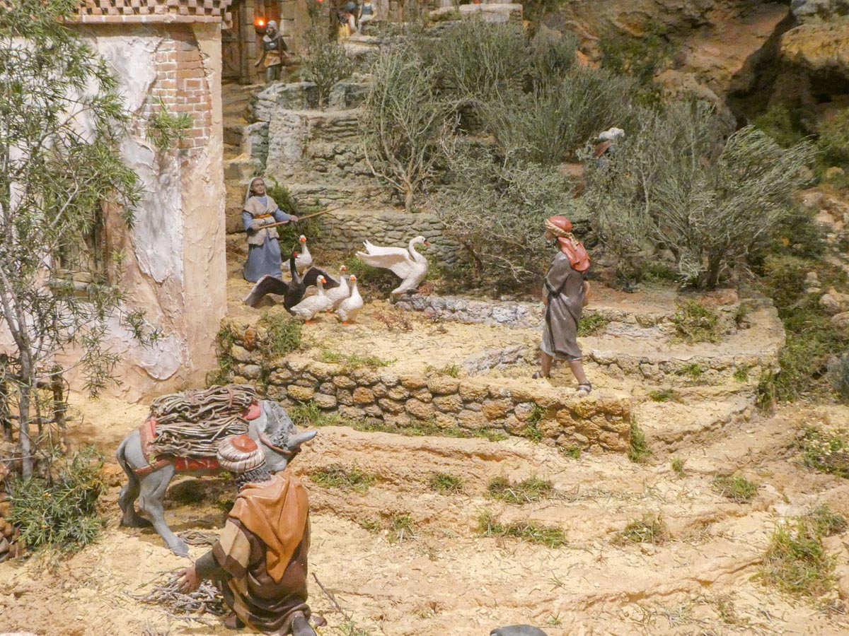 Escena pastoral con figuras de personas y animales en un entorno natural