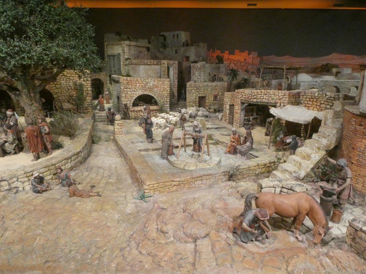 Representación de un pueblo histórico con artesanos y actividades cotidianas.