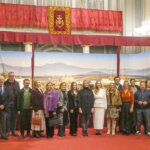 Grupo de personas posando en un evento con fondo decorativo