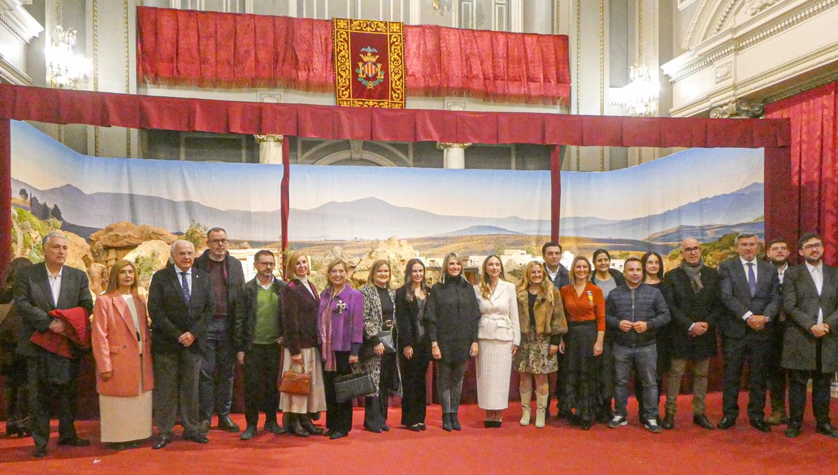 Grupo de personas posando en un evento con fondo decorativo