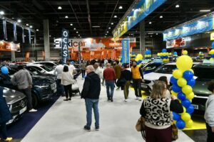 Asistentes en la Feria del Automóvil de Valencia con vehículos en exhibición