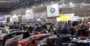 Multitud de personas en la Feria del Automóvil de València rodeados de coches