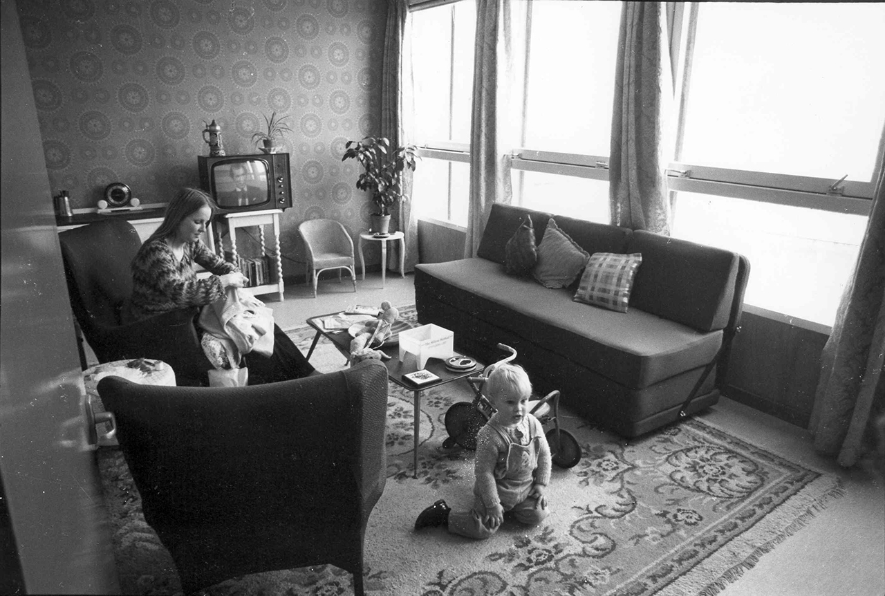 Una mare i el seu fill en un pis llogat amb decoració retro.