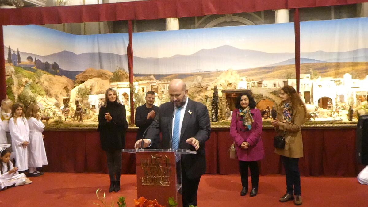 Inauguración de un belén navideño con varias personas en el escenario.