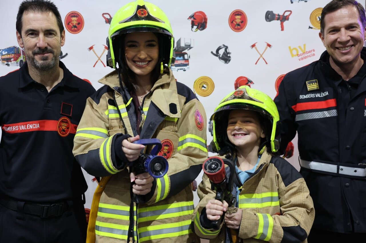 Personas en la inauguración de Expojove 2025 con trajes de bomberos