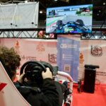 Joven jugando en simulador de carreras en Expojove 2025