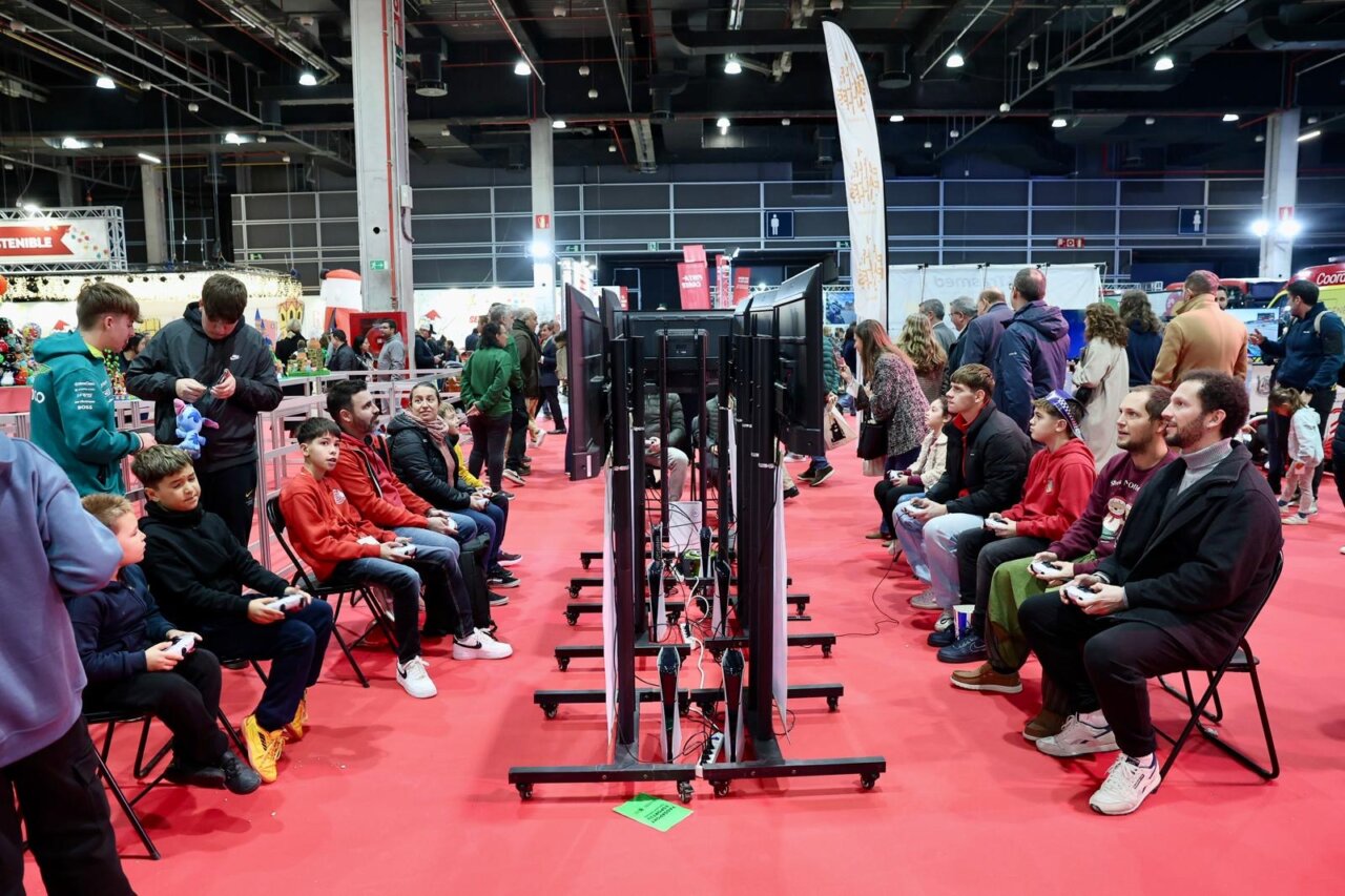 Personas jugando videojuegos en Expojove 2025 con pantallas grandes