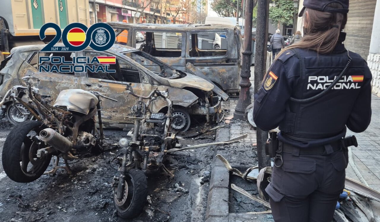 Policía Nacional observando vehículos dañados por incendio en Valencia