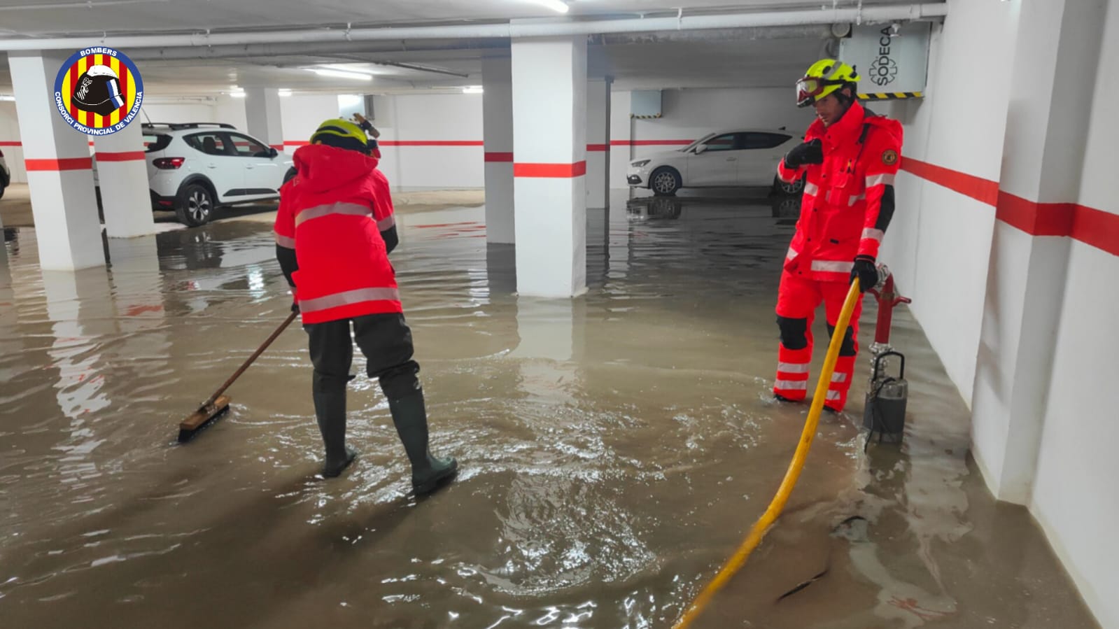 Bomberos trabajando en un garaje inundado por la intensa lluvia en la Horta Sud