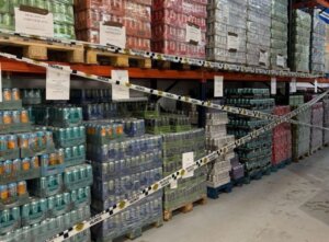 Latas de refrescos decomisadas en un almacén con cinta de seguridad.