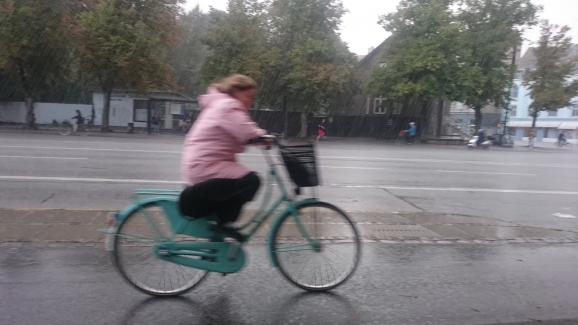 Mujer en bicicleta bajo la lluvia en Valencia