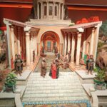 Maqueta de una escena antigua con figuras y arquitectura detallada.