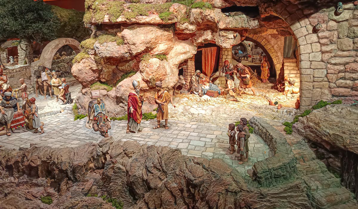 Escena de un belén con figuras artesanales en un paisaje rocoso
