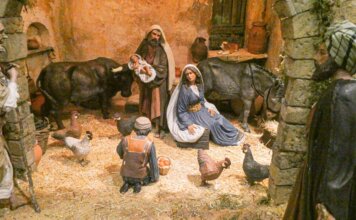 Belén monumental del Ayuntamiento de Valencia 2025 Escena de nacimiento con figuras de animales y pastores en un establo.