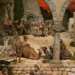 Escena de un nacimiento con camellos y pastores en un entorno rústico.