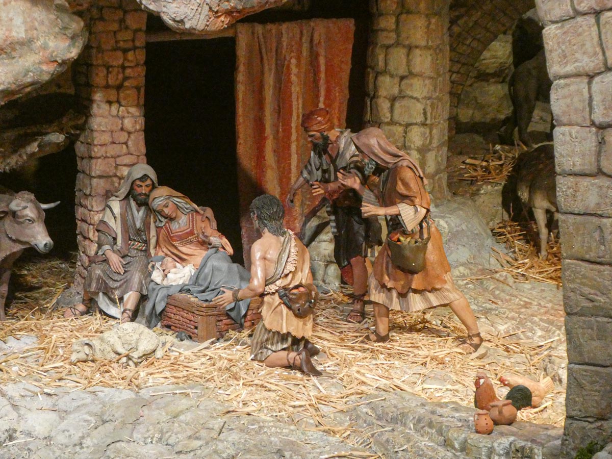 Escena del nacimiento de Jesús con pastores y animales.