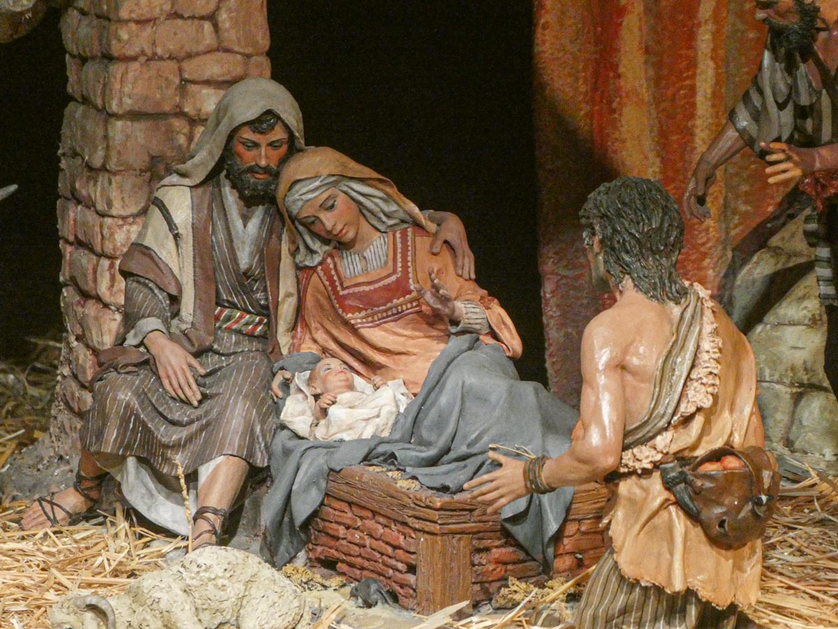 Escena del nacimiento de Jesús con figuras en un pesebre.