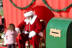 Niña interactuando con Papá Noel en un evento navideño