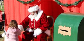 Niña interactuando con Papá Noel en un evento navideño