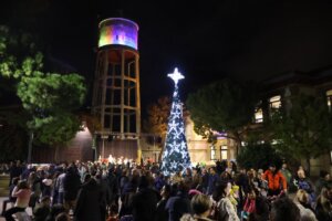 Celebración navideña en Massanassa con árbol iluminado y gente disfrutando.
