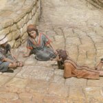 Tres figuras de niños jugando en una calle empedrada