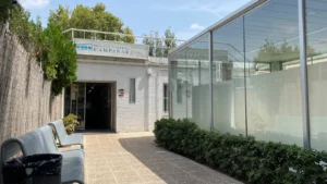 Entrada de la piscina cubierta Campanar en Valencia con vegetación