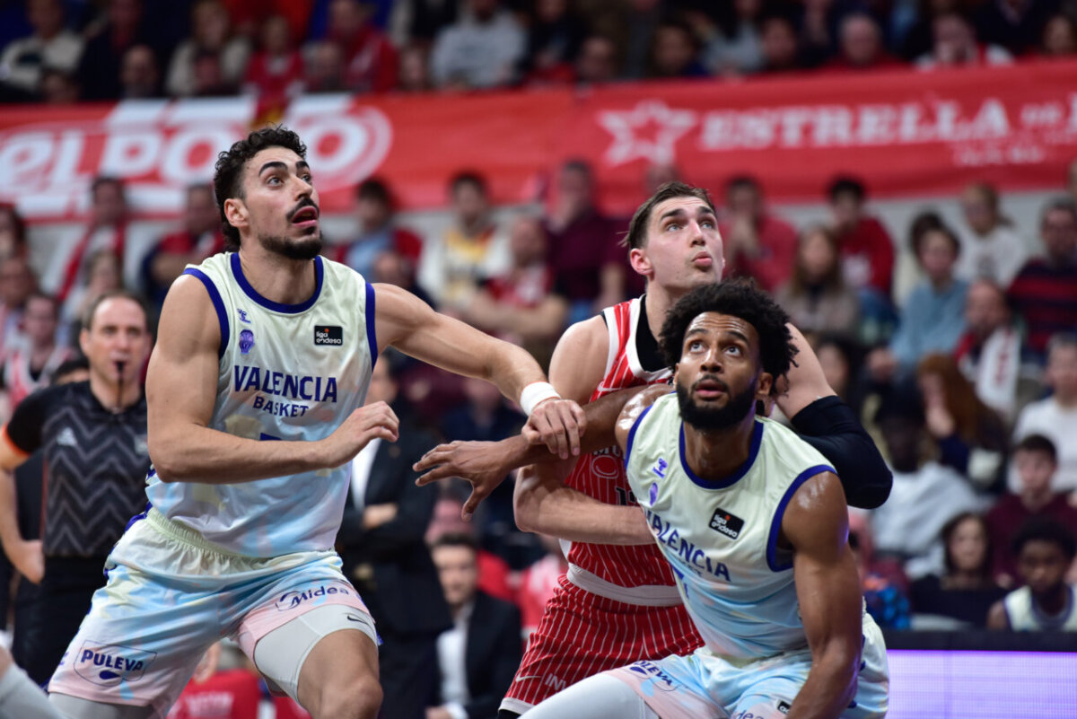 Jugadores de Valencia Basket luchando por el rebote en un partido de baloncesto