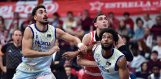 Jugadores de Valencia Basket luchando por el rebote en un partido de baloncesto
