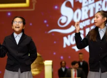 Niñas cantando los números del Sorteo de Navidad en un escenario
