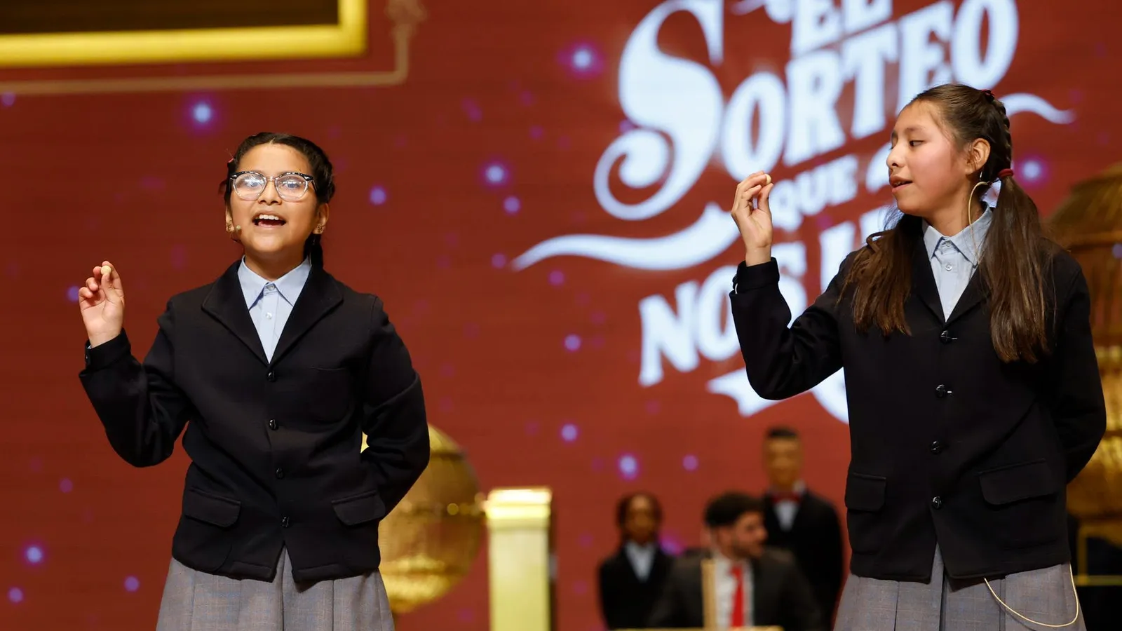 Niñas cantando los números del Sorteo de Navidad en un escenario