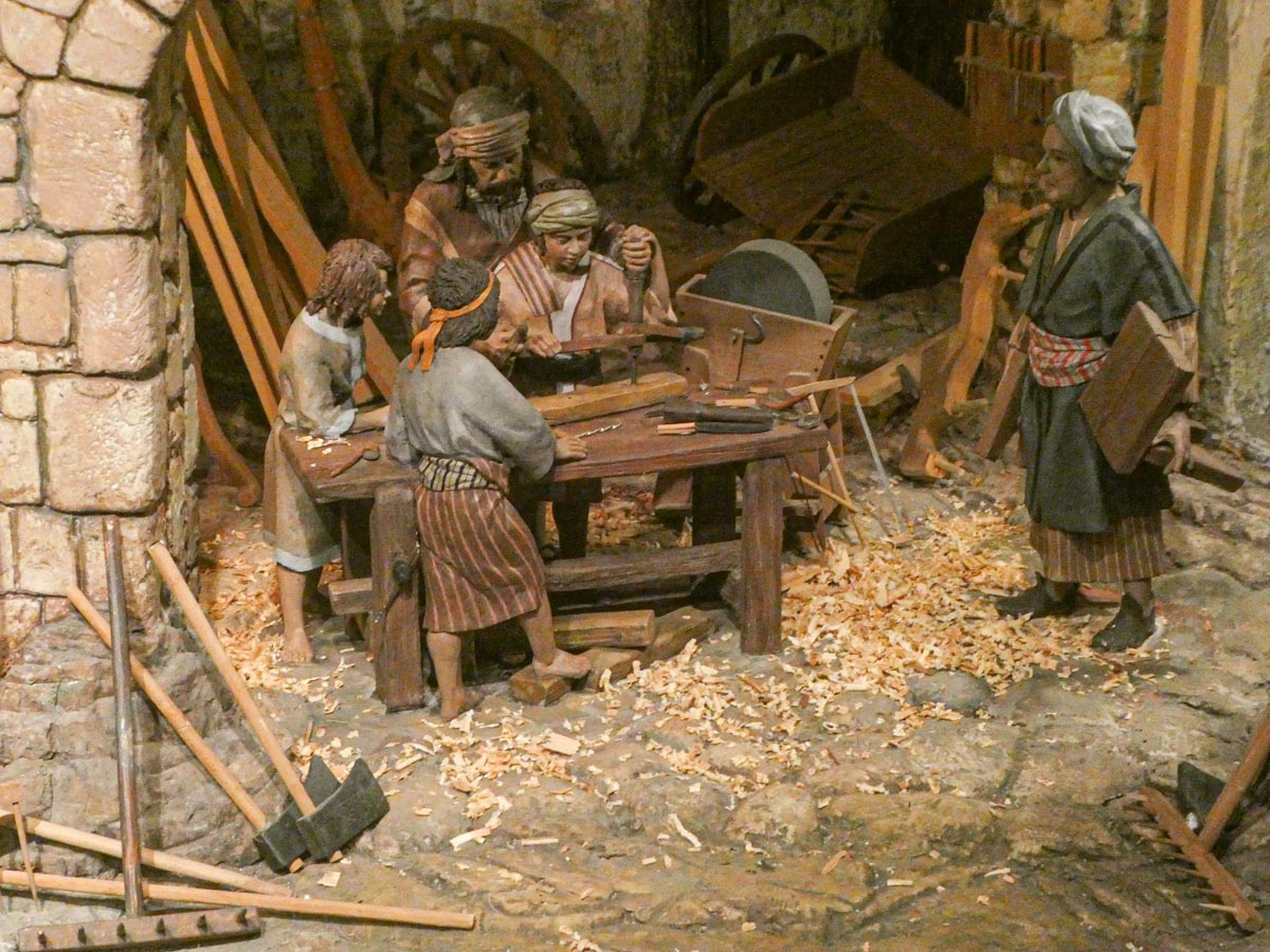 Escena de un taller con artesanos trabajando la madera