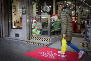 Mujer caminando sobre una alfombra navideña en Torrent