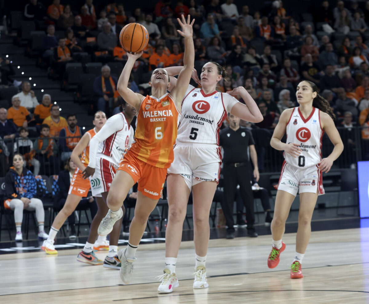 Jugadora de Valencia Basket intenta anotar mientras es defendida por jugadoras de Casademont Zaragoza.