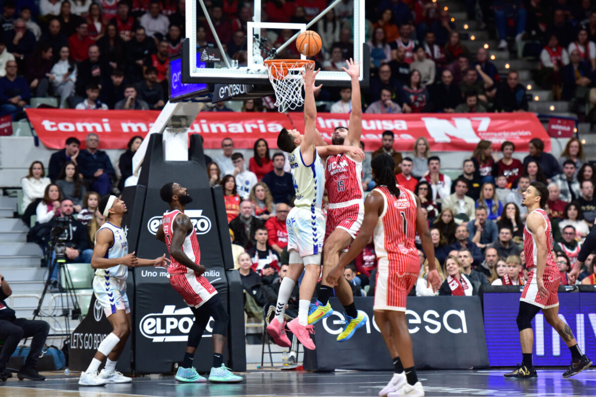 Jugadores de baloncesto en acción durante un partido de UCAM Murcia contra Valencia Basket.