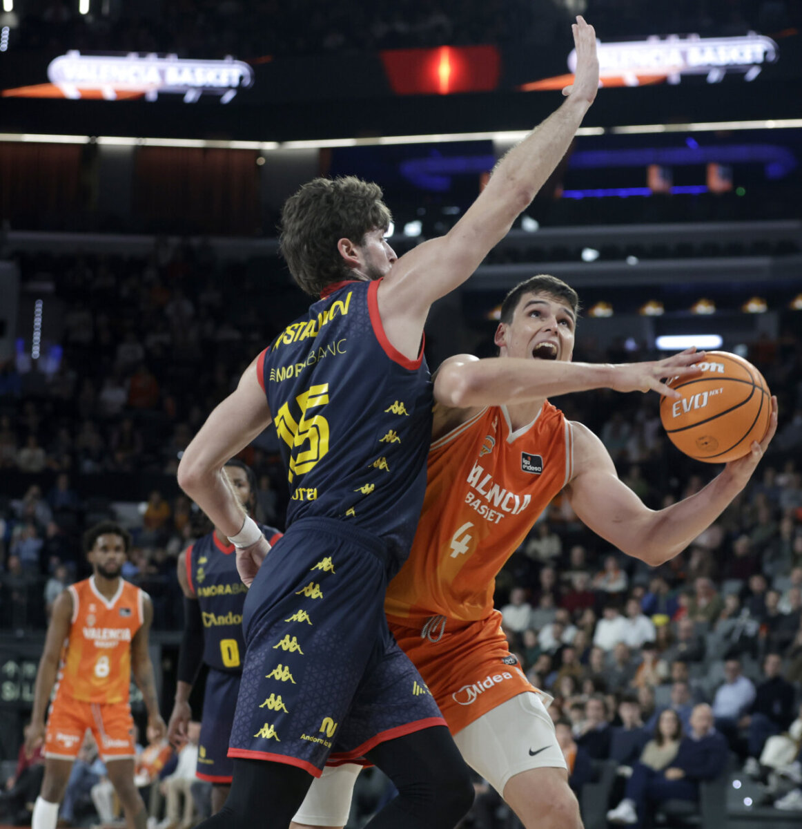 Jugadores de Valencia Basket y MoraBanc Andorra compiten en un partido de baloncesto.