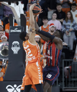 Jugadores de Valencia Basket y Baskonia luchando por el balón en un partido de EuroLeague.
