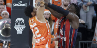 Jugadores de Valencia Basket y Baskonia luchando por el balón en un partido de EuroLeague.