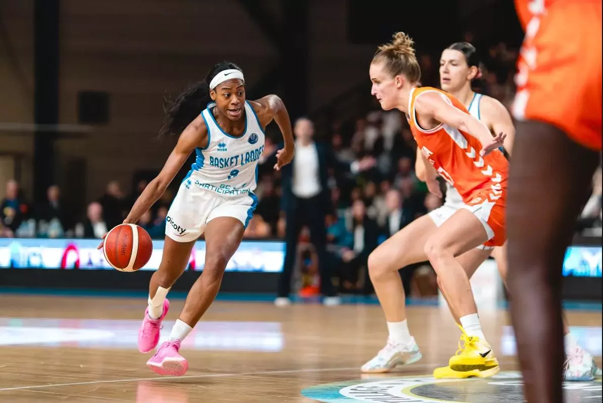 Jugadora de Basket Landes driblando el balón durante un partido de baloncesto.