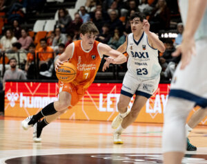Jugador de Valencia Basket U22 driblando el balón durante un partido contra Manresa.