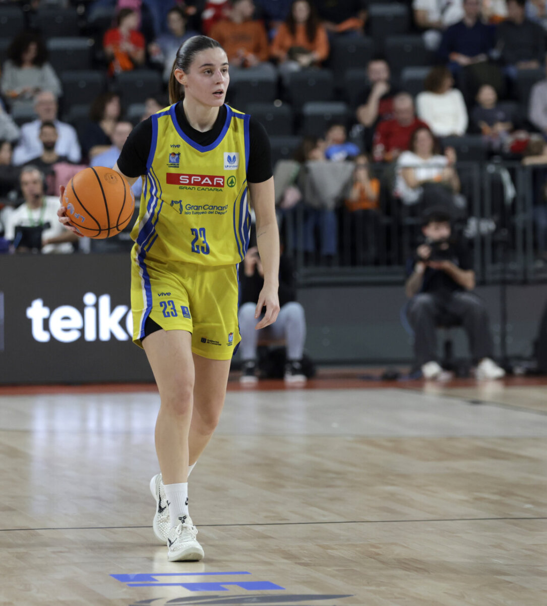 Jugadora de baloncesto con balón en la cancha del Roig Arena.