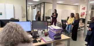 Reunión en oficina con varias mujeres conversando y trabajando.