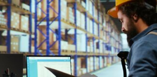 Operario revisando inventario en un almacén con sistema ERP