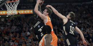 Jugadores de Valencia Basket y Bayern Múnich compiten por el balón en un partido emocionante.