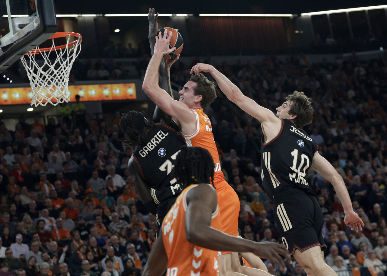 Jugadores de Valencia Basket y Bayern Múnich compiten por el balón en un partido emocionante.