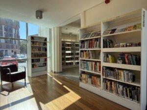 Interior de la biblioteca pública con estanterías llenas de libros y un sillón